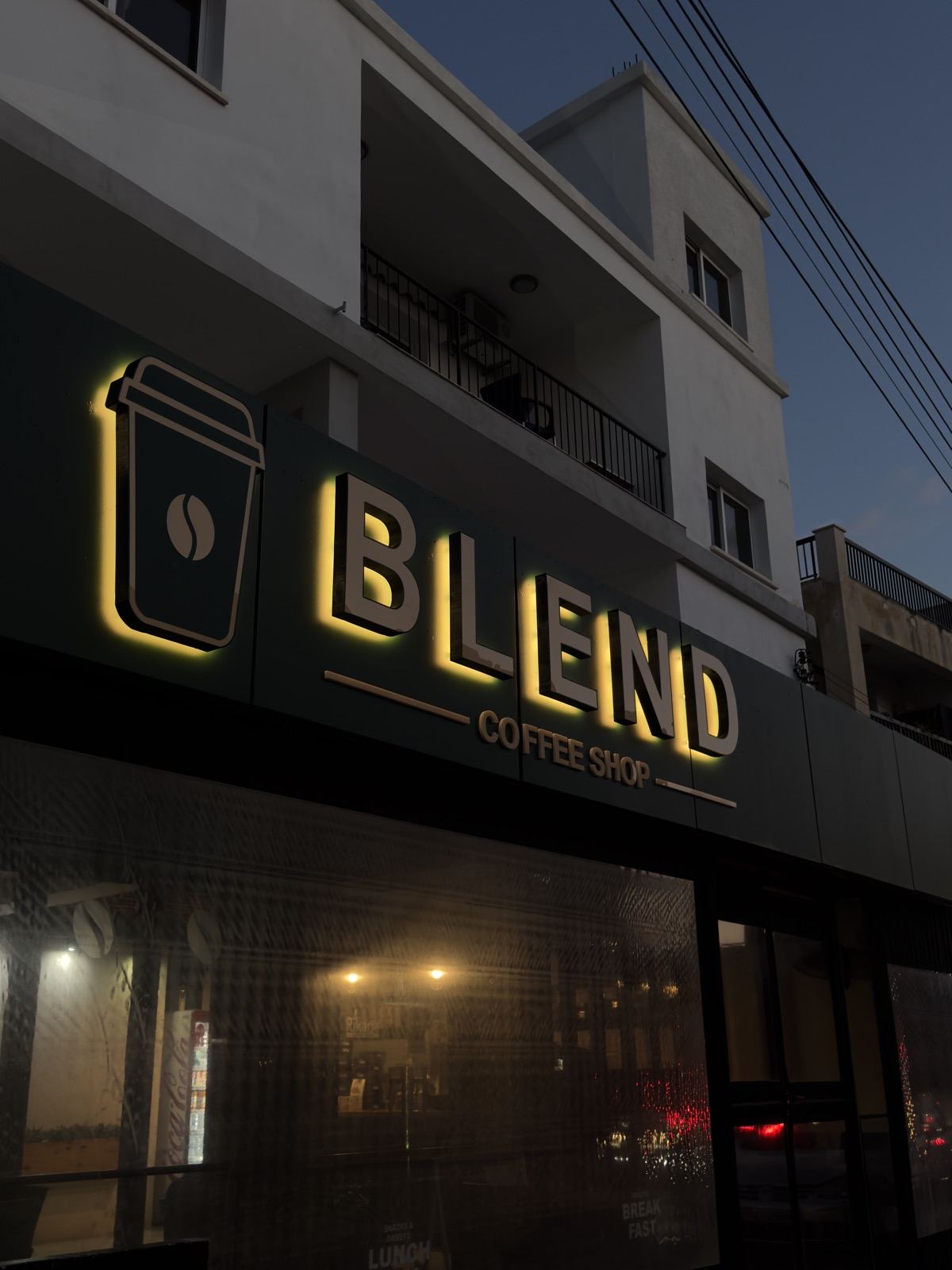 The illuminated Blend Coffee Shop sign on Akamantidos, Chloraka, at dusk